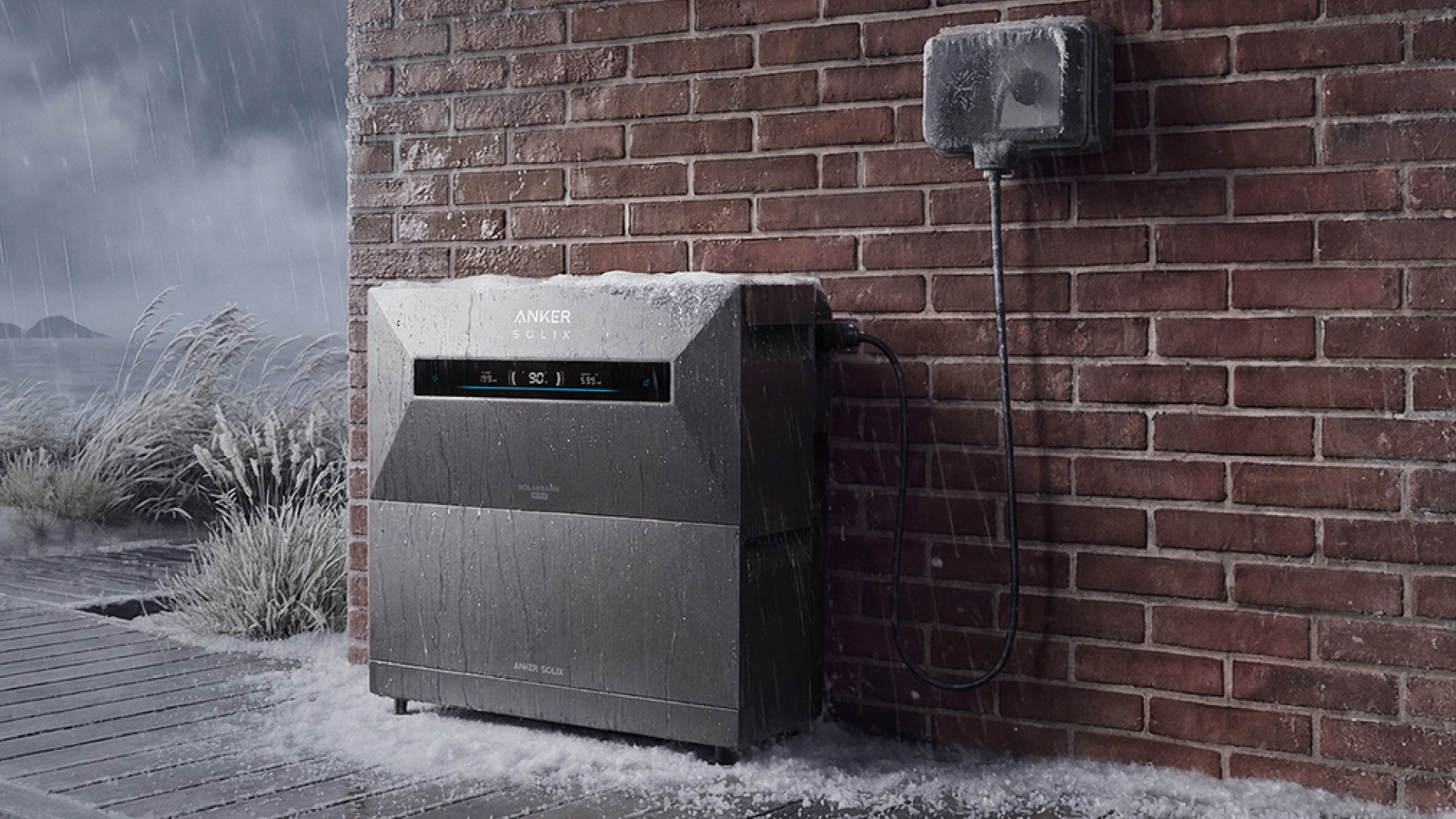 Anker SOLIX Solarbank Max AC im Freien an einer Backsteinwand bei Regen und Schnee, Küste im Hintergrund